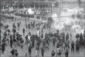  ?? AP/FAREED KHAN ?? fire tear gas to disperse Shiite Muslims during an anti-U.S rally, when they tried to march toward the U.S. Consulate in Karachi, Pakistan, on Sunday.