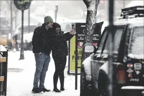  ?? RACHEL GIBBONS/HE DAILY NEWS-SUN ?? A COUPLE TAKES A SNOWY SELFIE IN DOWNTOWN FLAGSTAFF on Tuesday afternoon. Bitter cold, rain and snow blew across much of the Southwest U.S. on Tuesday, closing stretches of interstate and state highways in northern Arizona.