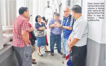  ??  ?? Chong (second right) talking to other stamp collectors in Kuching while waiting for the Kuching General Post Office to open for business. — Photos by Wilfred Pilo