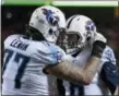  ?? ED ZURGA — THE ASSOCIATED PRESS ?? Titans quarterbac­k Marcus Mariota (8) celebrates with offensive tackle Taylor Lewan after scoring a touchdown during the second half of Saturday’s AFC Wild Card game.