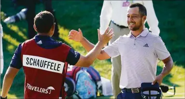  ?? Seth Wenig / Associated Press ?? Xander Schauffele celebrates with his caddie after finishing on the 18th hole during the final round of the Travelers Championsh­ip Sunday in Cromwell.