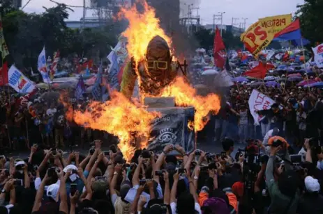  ?? TED ALJIBE/AFP/GETTY IMAGES ?? Protesters burn an effigy of Philippine President Benigno Aquino during a rally in Manila on Monday to coincide with his last state of the nation address.