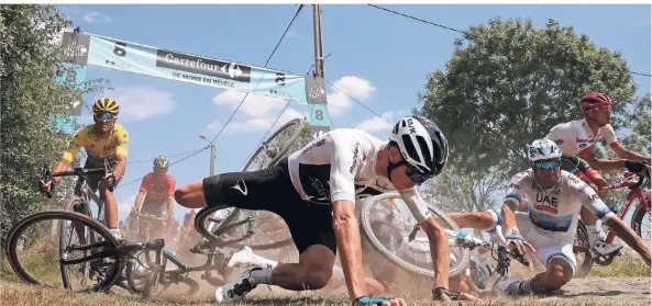  ?? FOTO: REUTERS ?? Auf der Etappe von Arras nach Roubaix am Sonntag stürzt Chris Froome (Team Sky, Mitte), kann aber weiterfahr­en. Der Führende Greg Van Avermaet im Gelben Trikot (l.) weicht aus.