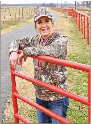  ?? STACI VANDAGRIFF/RIVER VALLEY & OZARK EDITION ?? Lori Reynolds stands at the gate of Circle Z Ranch in Greenbrier, a farm that she and her husband, Terry, manage. The couple also own about 100 head of beef cattle. Lori Reynolds is an award-winning nurse at Conway Regional Medical Center by day and helps her husband on the farm when she’s not at the hospital.