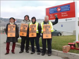  ?? ANDREA PEACOCK/The Daily Courier ?? From left, Maggie Wileman, Russell Malin, Michelle Boisvert and Jan Fensom picket Monday morning outside the Canada Post office on Gaston Avenue in Kelowna.