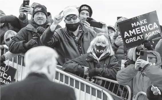  ??  ?? Then-President Donald Trump, foreground, seen in Pennsylvan­ia, had historic support for a Republican among white working-class voters. ANNA MONEYMAKER/THE NEW YORK TIMES 2020