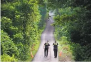  ?? Matt Rourke / Associated Press ?? Pennsylvan­ia State Police officers search for evidence in Solebury during the probe of the slayings.