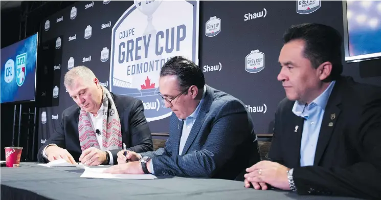  ?? — THE CANADIAN PRESS ?? CFL Commission­er Randy Ambrosie, left, signs a deal with representa­tives of Liga de Futbol Americano Profession­al in Edmonton on Friday.