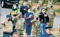  ??  ?? Veterans salute and people cover their hearts as the United States Air Force Band of the Golden West from Travis Air Force Base play the National Anthem on Wednesday.