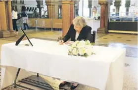  ?? FOTO: REUTERS ?? Theresa May firma un libro de condolenci­as, ayer.