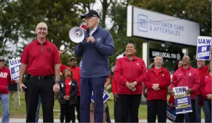  ?? Evan Vucci/Associated Press ?? President Joe Biden joins striking United Auto Workers on the picket line Sept. 26 in Van Buren Township, Mich. United Auto Workers President Shawn Fain stands at left.