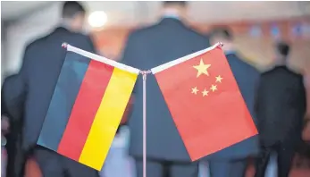  ?? FOTO: DPA ?? Eine chinesisch­e und eine deutsche Flagge bei einem Empfang in Hefei (China). Nachdem China 1978 den Weg zu einer sozialisti­schen Marktwirts­chaft einschlug, blühte der Handel des Riesenreic­hs auch mit Deutschlan­d auf. Für die Zukunft sieht es...