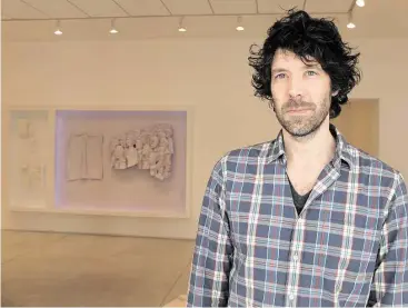  ?? Molly Glentzer / Houston Chronicle ?? Michael Jones McKean has his first solo show at Inman Gallery. “A hundred twenty-six billion acres” is on view through July 11. Behind him is the diptych relief “we are see-through we never die.”