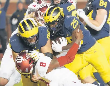  ?? CARLOS OSORIO/AP ?? Michigan offensive lineman Andrew Vastardis, left, takes down Indiana linebacker James Miller (8) as running back Hassan Haskins (25) scores during the first half on Saturday.