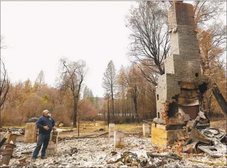  ?? Photograph­s by Carolyn Cole Los Angeles Times ?? HOMEOWNER Rob Lowe looks at a chimney teetering above the remains of his home in Concow, Calif., where he and his wife ran an organic apple orchard. Considerin­g it a safety hazard, he tried, unsuccessf­ully, to knock the chimney down by throwing bricks at it.