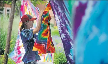  ?? [TOM DODGE/DISPATCH] ?? Ron Grantham, 55, hangs his tie-dye creations at Goodale Park to photograph them. Grantham said he learned how to tiedye when he picked up some riders in 1993 headed to a Grateful Dead show and has sold his work at Comfest for the past 20 years.