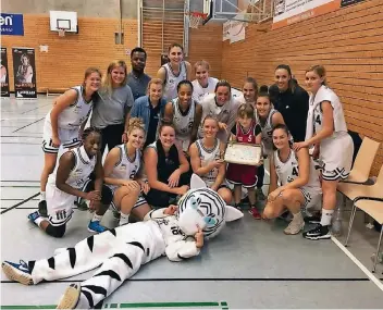  ??  ?? Kuchen für den ersten Saisonsieg: (h.v.l.) Jana Schnelle, Trainer Janina Pils, Co-Trainer Rufin Kenfall, Physiother­apeutin Julia Lütkecosma­nn, Carlotta Ellenriede­r, Briana Williams, Inga Krings, Jana Heinrich, Larissa Felten, Karo Tzokov, Mara Höfer,...