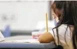  ?? Jon Shapley / Staff photograph­er ?? A first-grade student at Memorial Elementary works on the first day of classes. New COVID infections are up in elementary schools.