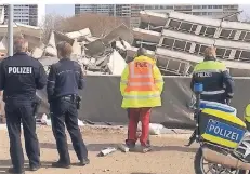  ?? FOTO: SCHWERDTFE­GER ?? Einsatzkrä­fte der Polizei begutachte­n nach der Sprengung den Trümmerhau­fen, der vom Hochhaus übrig geblieben ist.