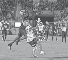  ?? ?? UCF’s DeJordan Mask, left, makes a leaping intercepti­on during the team’s 56-6 win over Kent State on Thursday.