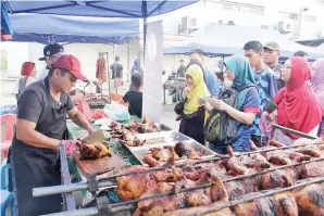  ??  ?? RAMAI pelanggan datang ke gerai Jafizan untuk membeli Ayam Golek Meletop. (gambar kanan) BAZAR Ramadan Indah Permai yang sesak orang ramai.