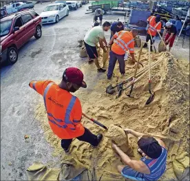  ?? RED HUBER / ORLANDO SENTINEL ?? Residents fill up sandbags Thursday in Orlando, Fla., as they prepare for Hurricane Irma. Long lines of vehicles waited for hours to get a 10-sandbag limit at the City of Orlando Public Works facility.