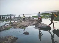  ?? MICHELE CATTANI / AFP VIA GETTY IMAGES ?? Malian children freshen in the cool waters of the Niger River before breaking the fast May 1. Mali has not closed its mosques to help contain the spread of the coronaviru­s.