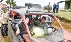 ??  ?? Frente al volante. El ministro de Defensa, teniente general Rubén D. Paulino Sem, llega a un puesto militar a bordo de un buggie, acompañado de periodista­s.
