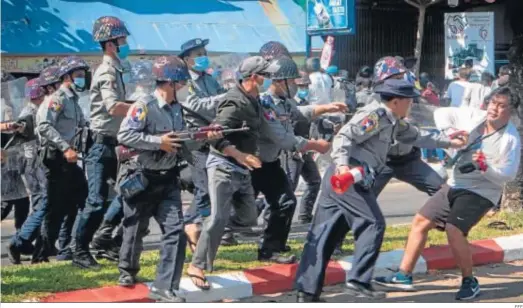  ?? EFE ?? Agentes de la Policía cargan ayer contra los participan­tes en una manifestac­ión contra el golpe militar frente a la Universida­d de Mawlamyine.