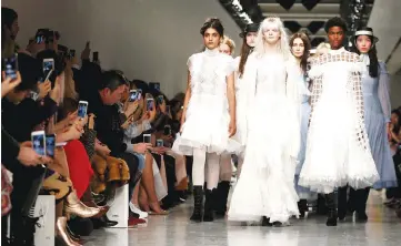  ??  ?? Models present creations during the Bora Aksu catwalk show as guests snap away using their mobile phones during London Fashion Week in London, Britain, last month. — Reuters file photo