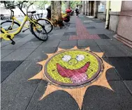  ?? ?? Graffiti painting on a manhole on Shanghai’s Wuyi Road — IC