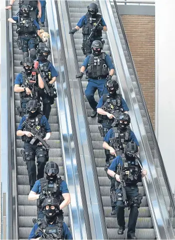  ?? Picture: PA. ?? Armed police descend an escalator near London Bridge station yesterday.