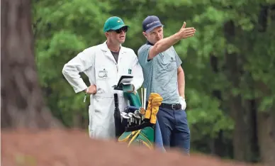  ?? PHOTOS BY ROB SCHUMACHER/THE REPUBLIC ?? Justin Rose and his caddie David Clark confer on the 11th hole during the second round of the Masters at Augusta National Golf Club in Augusta, Ga., on Friday. Rose leads by one shot at 7 under after 36 holes.