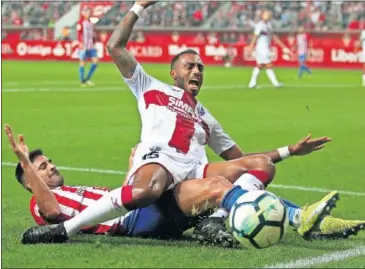  ??  ?? PELEA. Carmona y Akapo luchan por el balón en el partido de anoche en El Molinón.