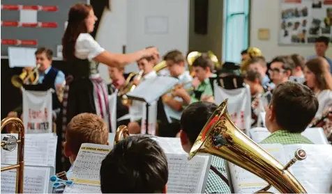  ??  ?? In der Aula statt im Pausenhof: Vom schlechten Wetter ließen sich die Buben und Mädchen der Bläserklas­sen sowie Musiklehre­rin Ingrid Harrer Hoffmann die gute Stimmung aber nicht verderben.