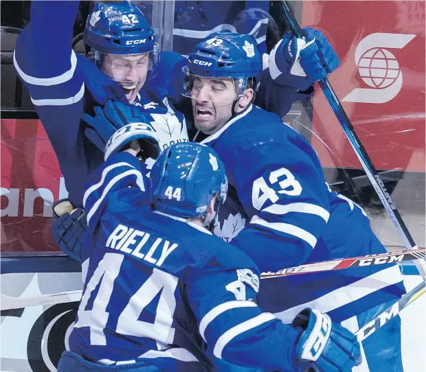  ?? TYLER ANDERSON / NATIONAL POST ?? Toronto’s Tyler Bozak (top) celebrates his game-winning goal Monday night with teammates Morgan Rielly and Nazem Kadri.