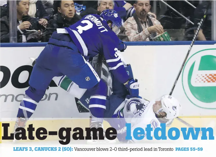  ?? DAVE ABEL ?? Toronto’s Travis Dermott lays out Vancouver’s Markus Granlund during the Canucks’ shootout loss Saturday night at the Air Canada Centre.