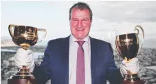  ??  ?? Trainer Darren with the Melbourne and Caulfield Cup trophies.