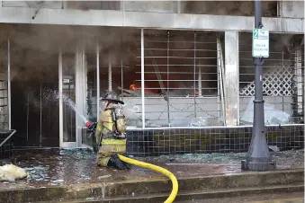  ?? Photo by Kate Stow ?? ■ A firefighte­r battles a blaze Thursday in downtown Atlanta, Texas.
