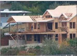  ?? (AP) ?? Builders work on a new house in October on the waterfront in Gig Harbor, Wash. The fourth-quarter decline in U.S. productivi­ty was the largest in nearly four decades.