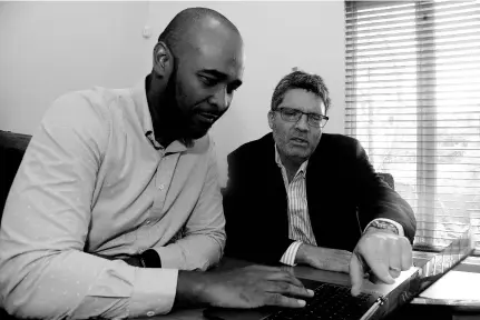  ??  ?? Head of brokering operations Peter Walker (left) and CEO William Craig consult about company operations at Billy Craig Insurance Brokers’ office in Kingston, on April 3.