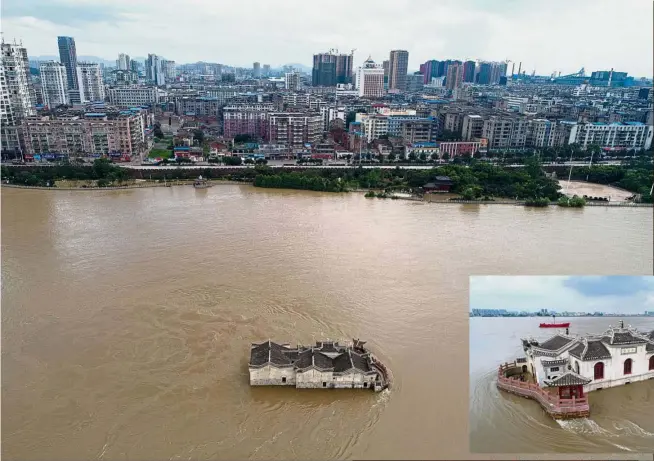  ?? — AFP ?? Isolated: An aerial view showing floodwater­s overwhelmi­ng a building in Ezhou, Hubei province. Severe rainfall in central China’s Hunan Province since last month has affected over 12 million people and left 83 dead or missing, according to the...