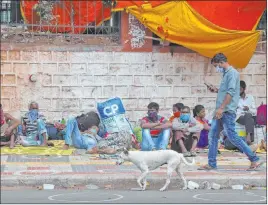  ?? Mahesh Kumar A. The Associated Press ?? Migrant workers rest on pavement Tuesday as they wait for trains to Hyderabad, India.