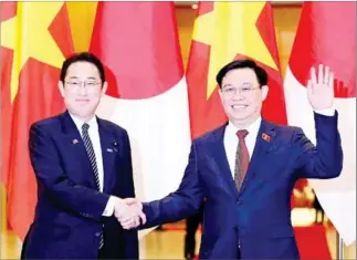  ?? POOL/AFP ?? Japanese Prime Minister Fumio Kishida (left) shakes hands with Vietnam’s National Assembly Chairperso­n Vuong Dinh Hue during a meeting in Hanoi on Sunday.