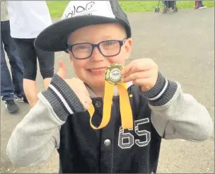  ??  ?? Children release balloons and collect medal for taking part in the sponsored walk