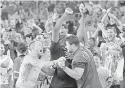  ?? AL DIAZ/TNS ?? Miami fans react after Michael Badgley’s game-winning field goal with four seconds to play against Georgia Tech back in October. The fans are back in droves and UM’s football team is a hot topic and a hot ticket.