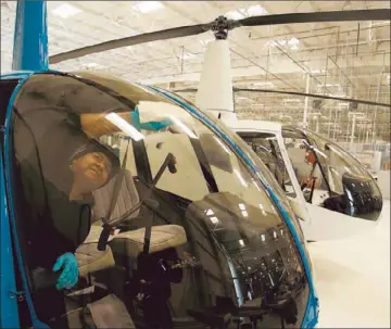  ?? Gary Friedman
Los Angeles Times ?? JUAN HUEZO wipes down the window of an R-44 at Robinson Helicopter Co. in Torrance early last year.