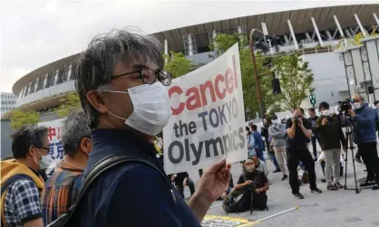  ?? Photograph: Rodrigo Reyes Marin/ ZUMA Wire/REX/Shuttersto­ck ?? People holding placards protest against the Tokyo Olympic Games outside the Japan Olympic Museum.