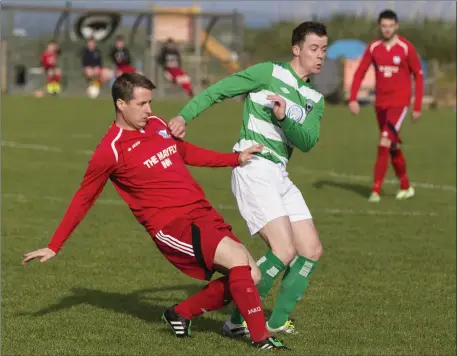  ??  ?? Strand Celtic’s Mark McGoldrick in action against Niall Craig of Aughanagh in a thrilling 4- 4 draw on Sunday.