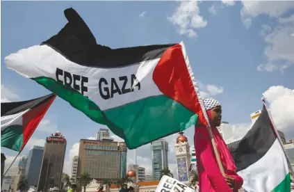  ?? (Olivia Harris/Reuters) ?? A GIRL holds a flag at a rally in support of Gaza in Kuala Lumpur.